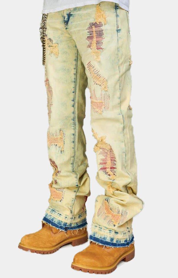 Distressed detail on light wash stacked denim jeans.