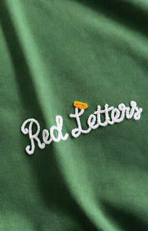 Premium green cotton tee with embroidered Red Letters branding.