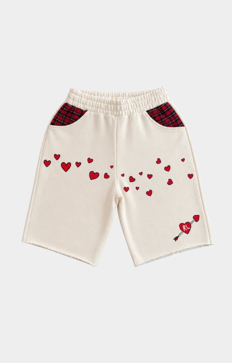 Red Letters Off-white knit shorts with red heart embroidery, red plaid pocket panels, and a small red heart-and-arrow motif near the lower right leg.