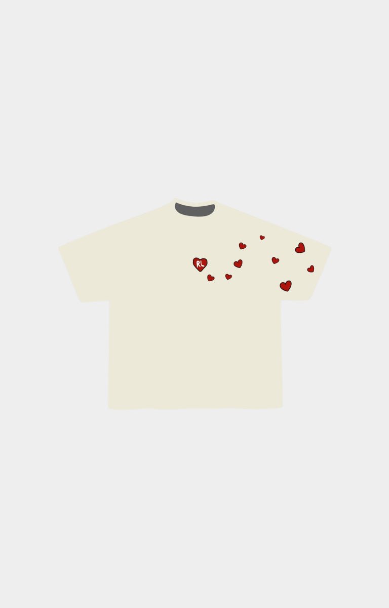 Red Letters Love letter cream-colored short-sleeve t-shirt with small red heart graphics scattered across the chest and shoulder area.