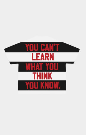 Graphic tee featuring You Can't Learn What You Think You Know message.