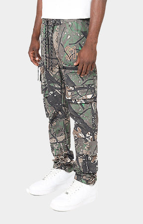 Smoke Rise camouflage cargo jogger pants with a adjustable drawstring waist and white sneakers. 