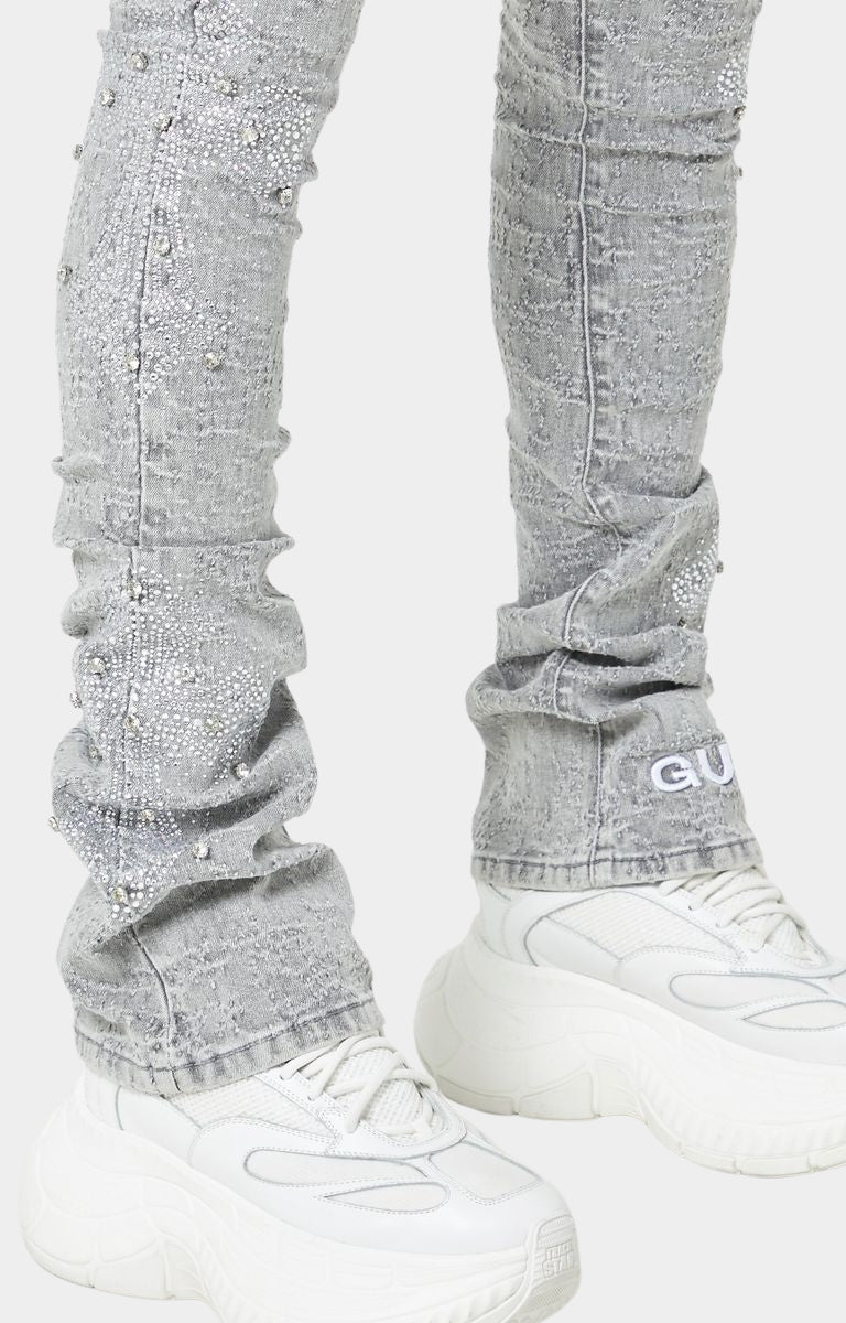 Urban fashion grey stacked jeans with white embroidered GUAPI logo.
