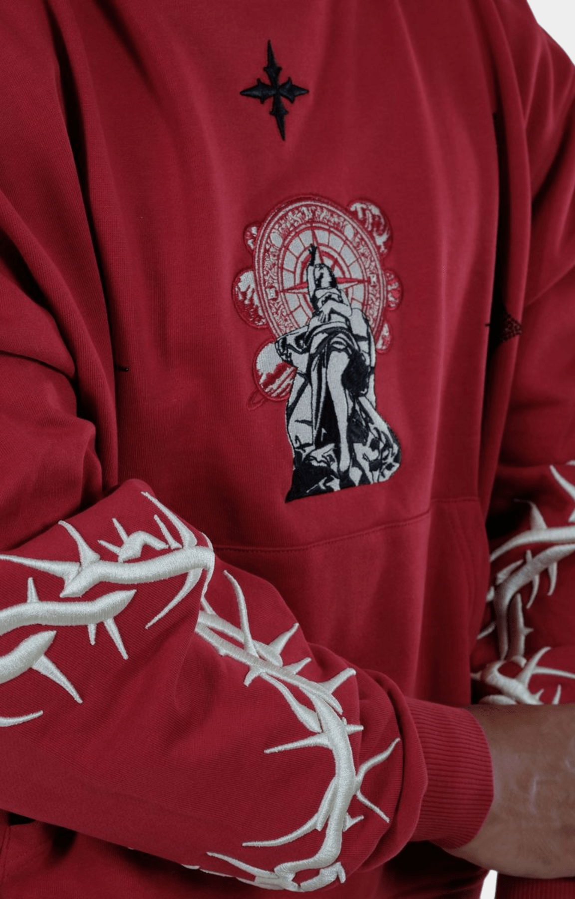 Close-up of embroidered sleeves on red Vie Riche Dark Angel Hoodie.